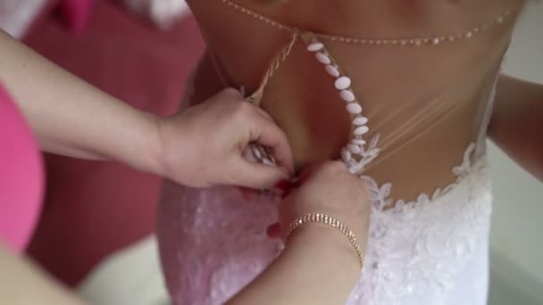 Bridesmaid buttoning bridal dress — Stock Video