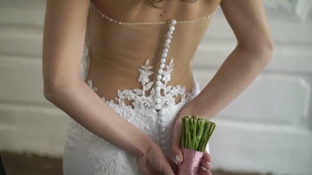 Mooie vrouw bruid in witte jurk verblijf met boeket — Stockvideo