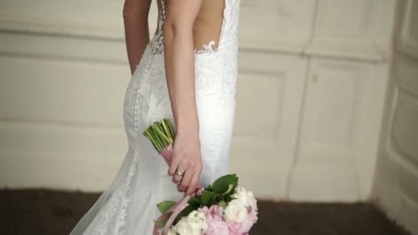 Beautiful woman bride in white dress staying with bouquet — Stock Video