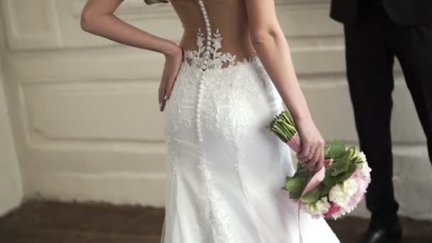 Schöne Braut im weißen Kleid bleibt mit Strauß — Stockvideo