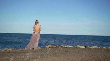 Deniz kenarında elbiseli sarışın genç kadın