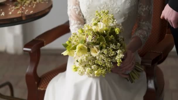 Braut sitzt mit Blumenstrauß — Stockvideo