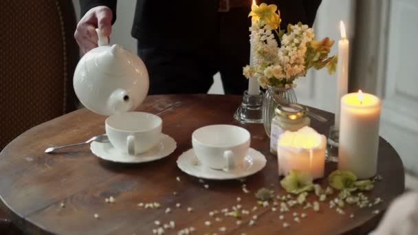 Человек наливает чай в чашку — стоковое видео