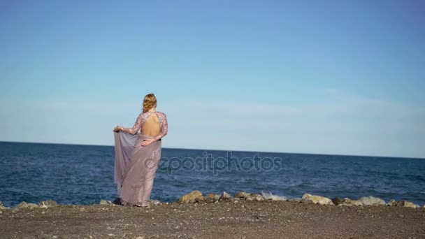 Junge blonde Frau im Kleid am Meer — Stockvideo