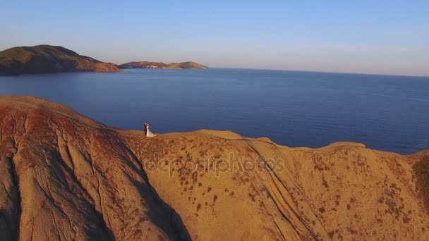 Mariée et marié marchant sur la montagne au coucher du soleil 