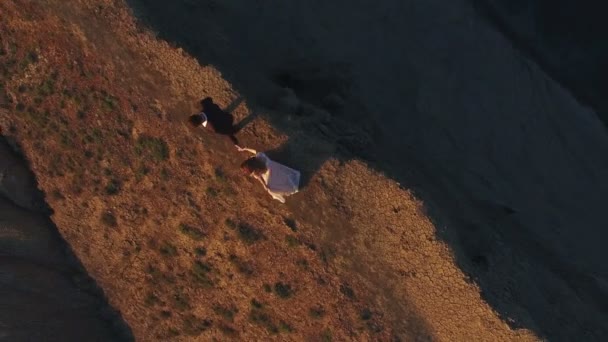Mireasa și mirele mergând pe munte la apus de soare — Videoclip de stoc
