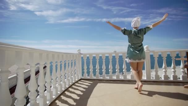 バルコニーに来る若い女性のバスローブ — ストック動画