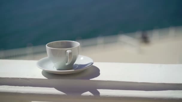 Mujer joven toma una taza de café cerca del mar — Vídeos de Stock