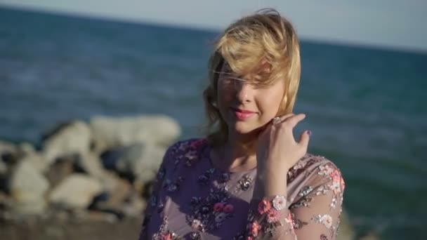 Ung blond kvinna i klänning nära havet — Stockvideo