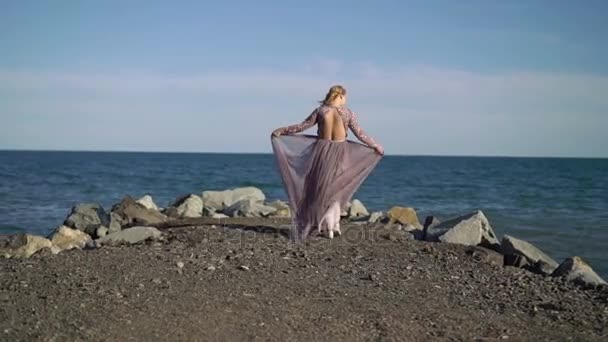 Wanita pirang muda berpakaian dekat laut — Stok Video
