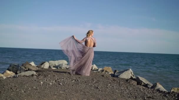 Jonge blonde vrouw in jurk in de buurt van de zee — Stockvideo