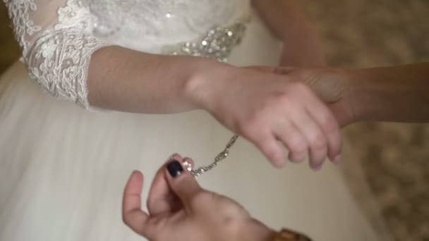 Bridesmaid wearing bracelet to bride hand — Stock Video