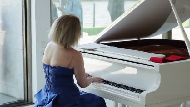 Kvinna spelar vit piano — Stockvideo