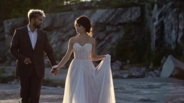 Gün batımında yürüyen genç güzel Çift