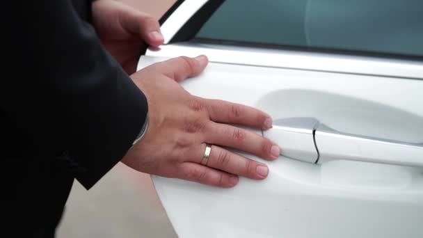 Mann schließt Tür von weißem Auto — Stockvideo