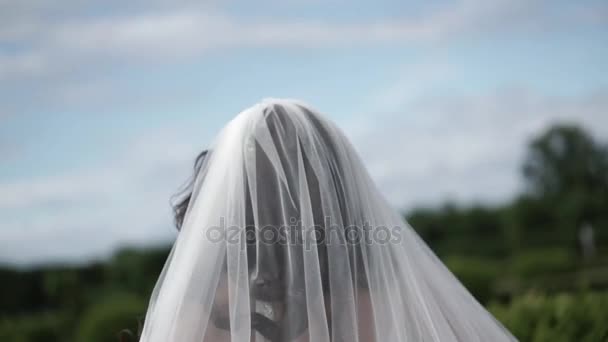 Noiva andando em um parque e acenando véu — Vídeo de Stock