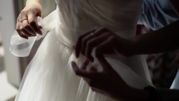 Bridesmaid helping bride put on belt — Stock Video