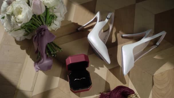 Dámská boty na podpatcích, kytice, snubní prsteny a klíče od pokoje — Stock video