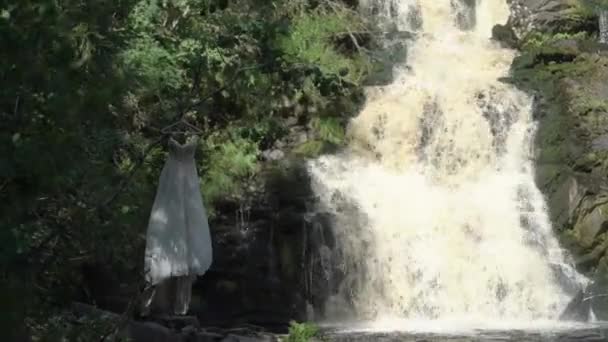 Robe de mariée près de cascade 