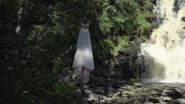 Robe de mariée près de cascade 