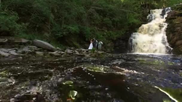 Casal jovem caminhando perto de cachoeira — Vídeo de Stock