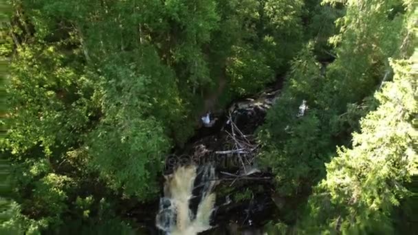 Jeune couple de mariage restant près de la cascade 
