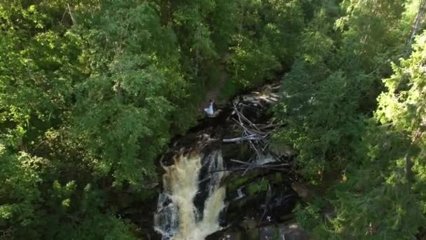 Jeune couple de mariage restant près de la cascade 