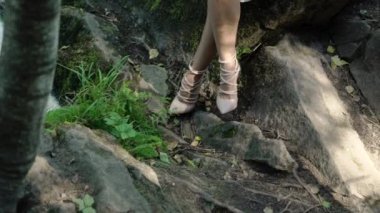 Şelale yakınındaki bir kayaya oturan genç kadın