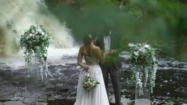 Genç evlilik çift yüzük şelale yakınındaki töreninde değişimi