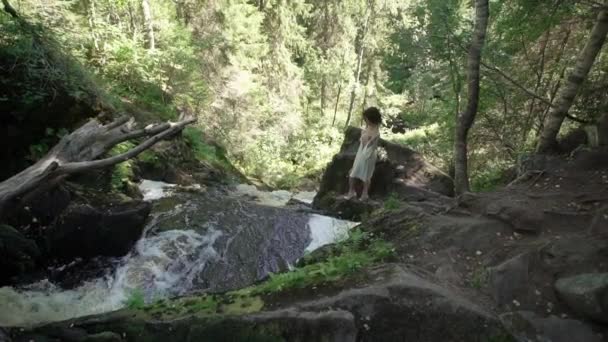 Młoda kobieta rozbieranie się w pobliżu wodospadu — Wideo stockowe