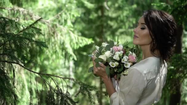 Young woman with bouquet in forest — Stock Video