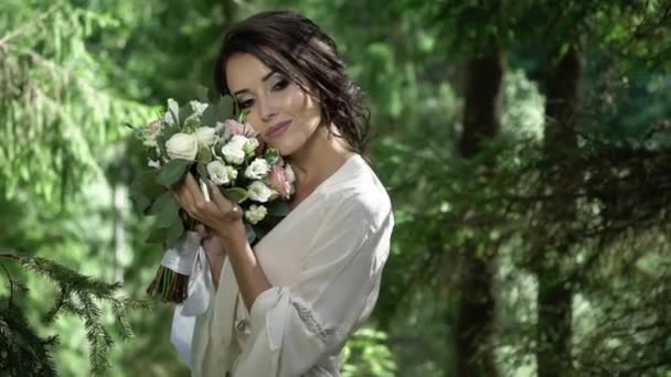 Junge Frau mit Blumenstrauß im Wald — Stockvideo