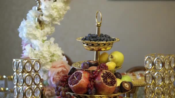 Tabell med frukter dekorerad med blommor — Stockvideo