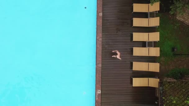 Молодой человек прыгает в бассейн — стоковое видео