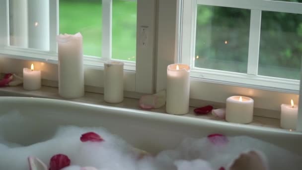 Jonge vrouw in badkamer met bloemblaadjes — Stockvideo
