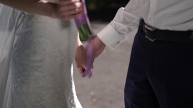 Gelin ve damat el ele tutuşuyorlar.