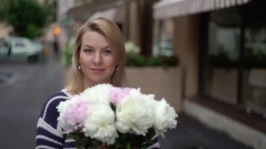 Buket çiçek ile yürüyen genç kadın