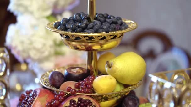 Стіл з фруктами, прикрашений квітами — стокове відео