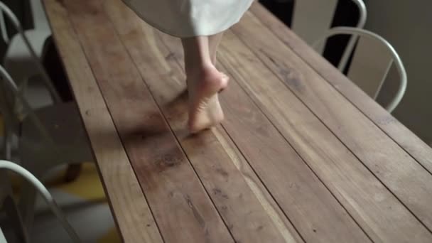 Young woman in dress walking on a table — Stock Video