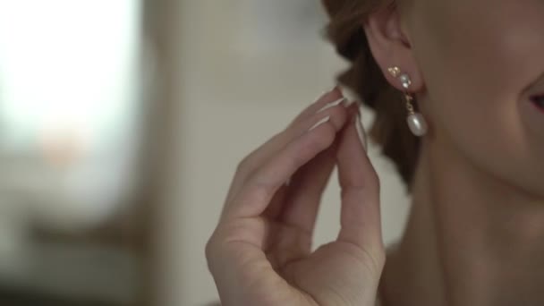 Νεαρή γυναίκα φοράει σκουλαρίκια — Αρχείο Βίντεο