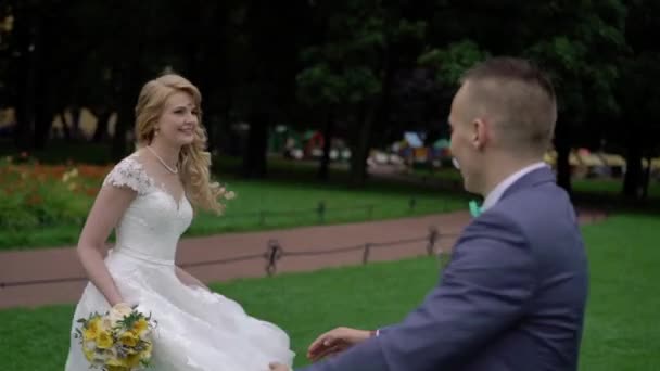 Bruid en bruidegom dansen in het park — Stockvideo