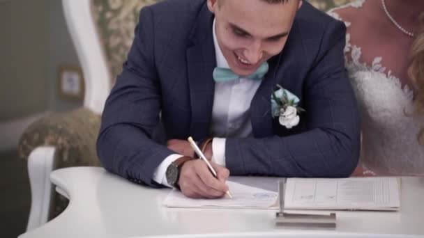 Menyasszony és a vőlegény az esküvő a dokumentumok aláírása — Stock videók