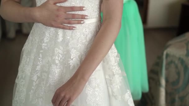 Bruidsmeisje helpt trouwjurk dragen — Stockvideo