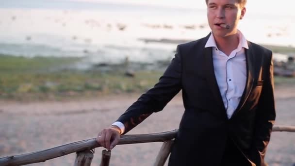 Мужчина курит на пляже — стоковое видео