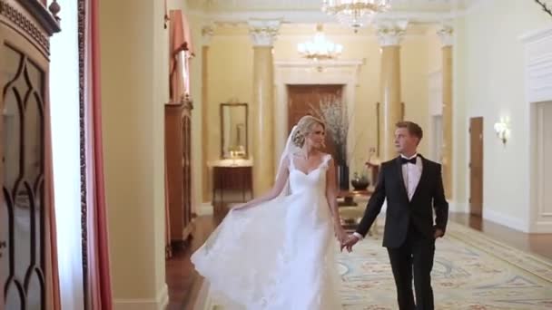 Braut und Bräutigam spazieren im Palast — Stockvideo