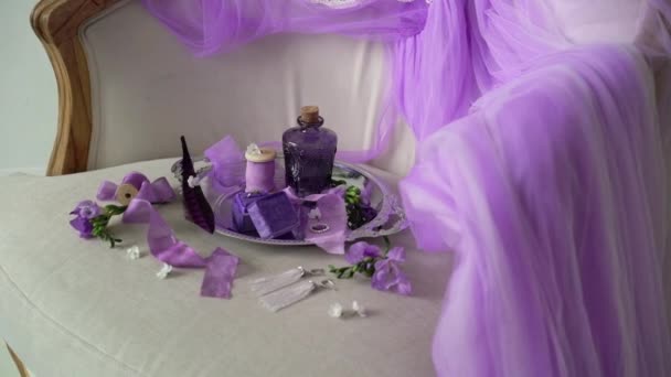 Violet dienblad met fles, sieraden ring en lingerie — Stockvideo