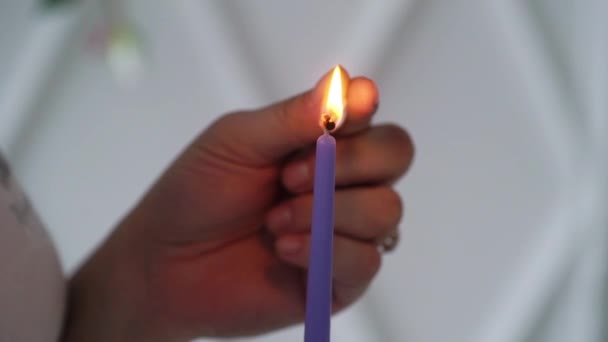 Frau zündet violette Kerze an — Stockvideo