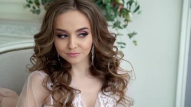 Genç ve güzel bir kadın beyaz iç çamaşırlarıyla poz veriyor.