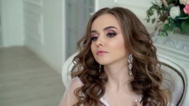 Genç ve güzel bir kadın beyaz iç çamaşırlarıyla poz veriyor.
