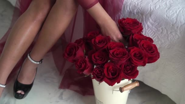Молодая брюнетка в красном белье берет красную розу — стоковое видео